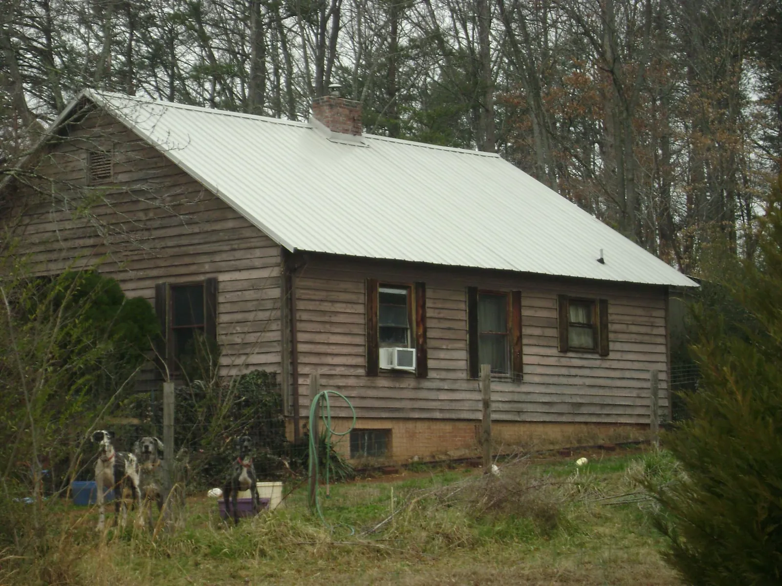 White metal roof on an old wood sided farmhouse, from a Metal Roof Installation job in Elgin
